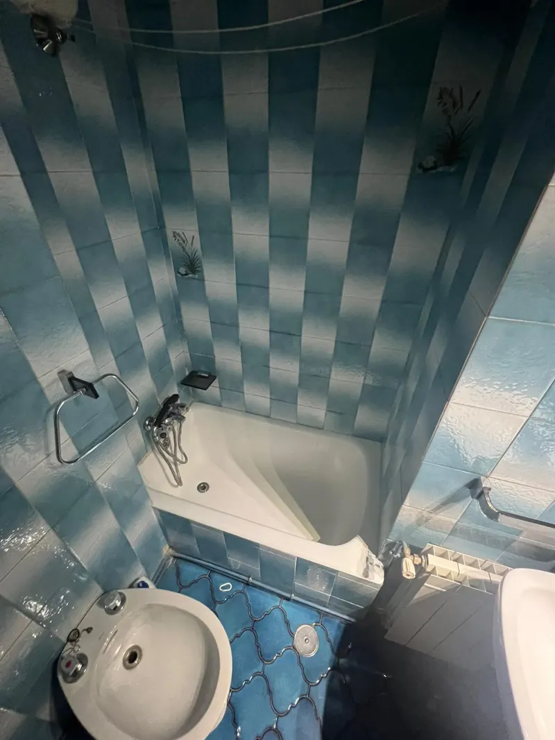 Baño antes de la reforma: bañera con azulejos azules